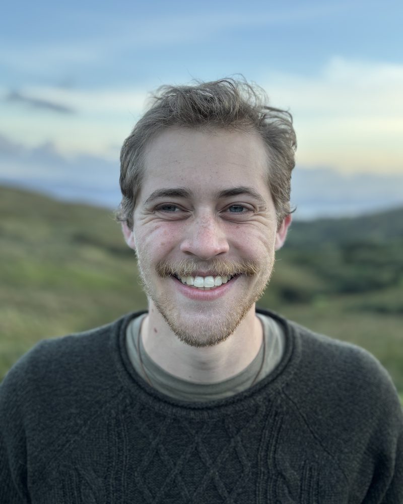Josh Carlile smiling on a hillside